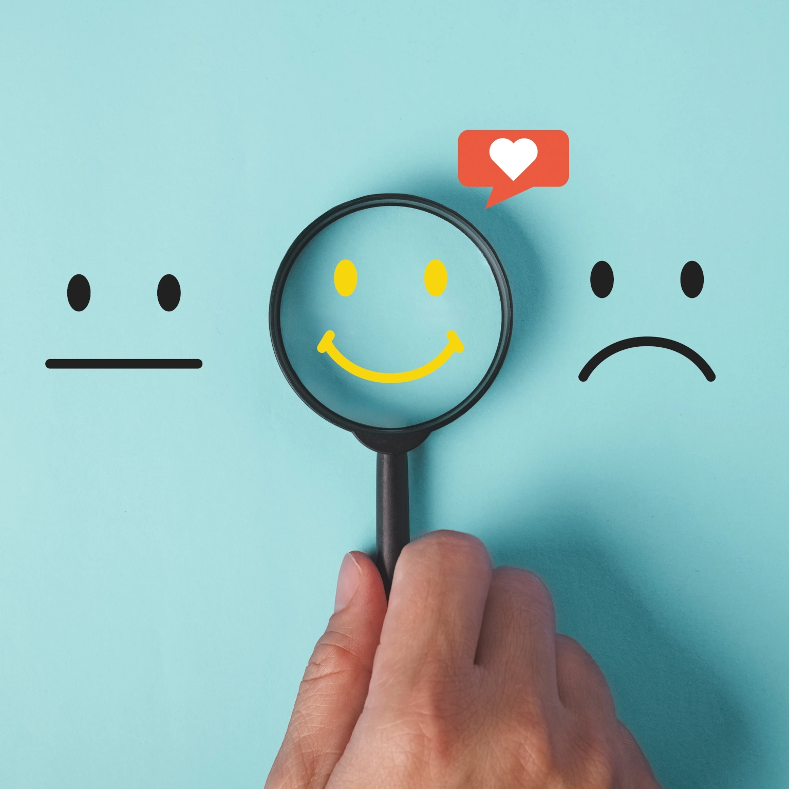 Drie smiley's op een rij, vergrootglas gericht op gele blije smiley met een like erbij.