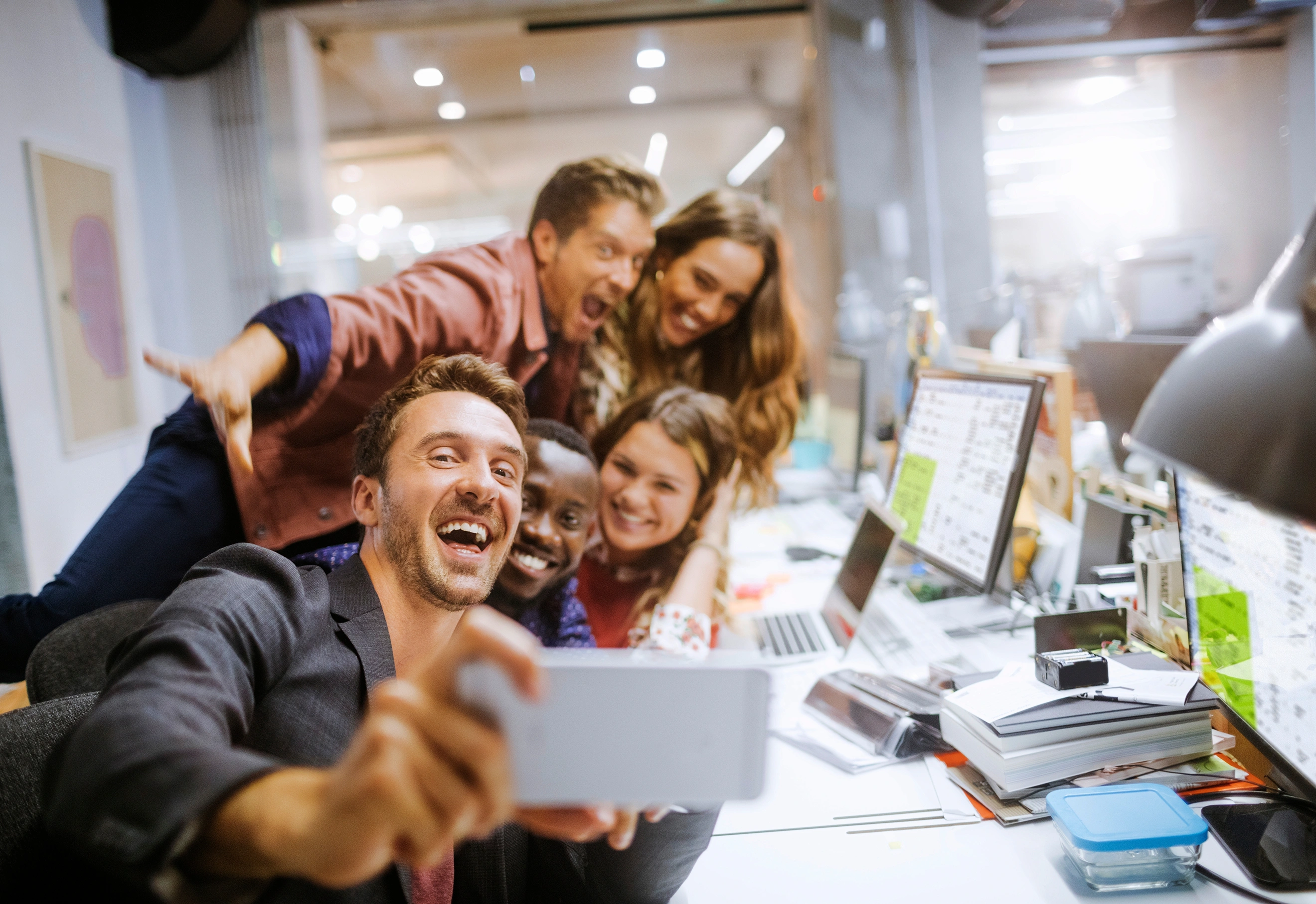 Een bevlogen team maakt op kantoor een selfie.